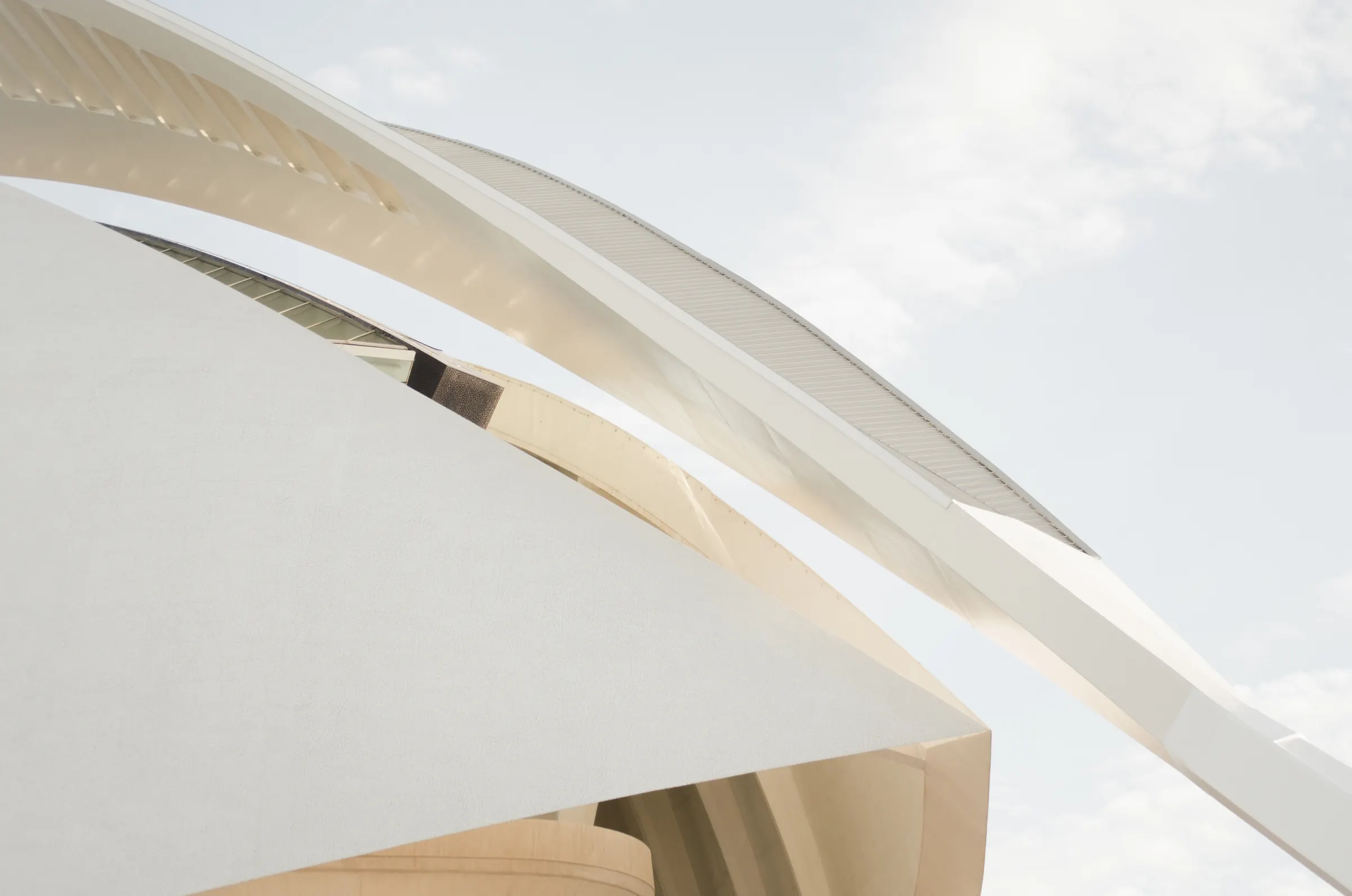 White architectural ribbons sweeping against a pale sky.